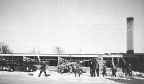 Workers erecting flag pole of new Taylors Falls School